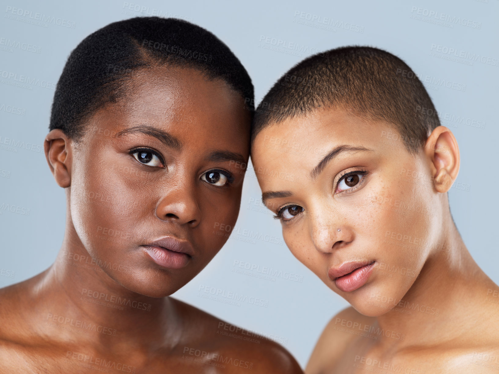 Buy stock photo Portrait of two beautiful young women standing close  to each other against a grey background