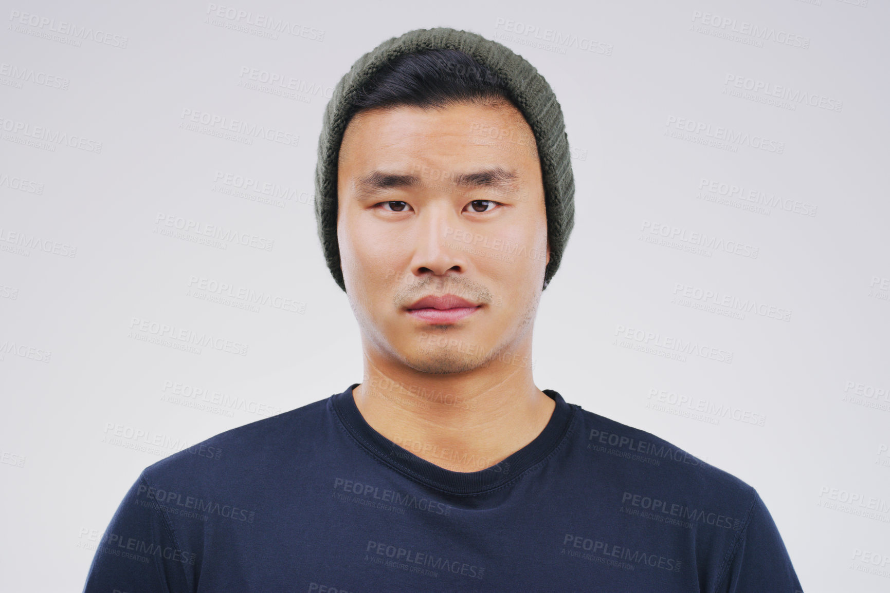 Buy stock photo Studio portrait of a handsome young man posing expressionless against a grey background