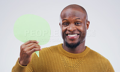 Buy stock photo Portrait of a handsome young man holding a speech bubble against a grey background