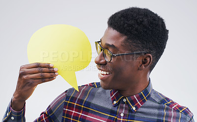 Buy stock photo Shot of a handsome young man holding a speech bubble against a grey background