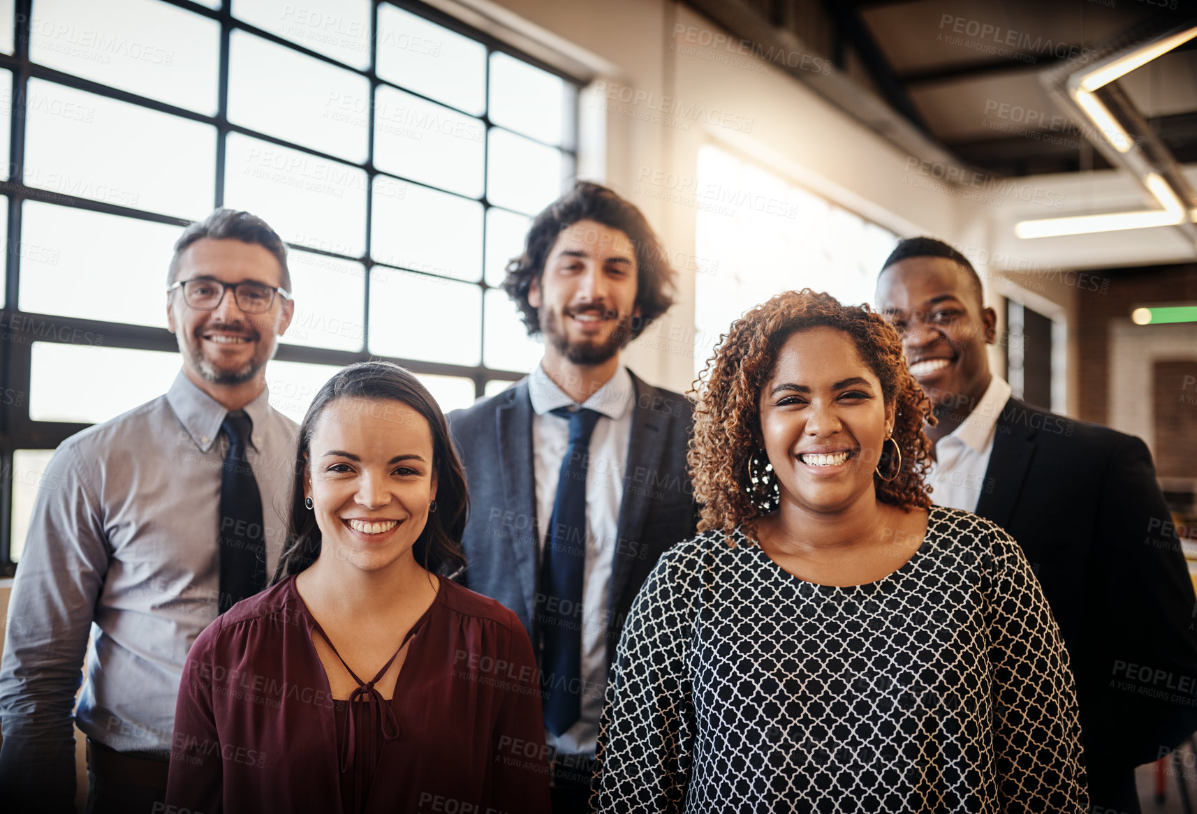 Buy stock photo Cropped portrait of a diverse team of happy businesspeople posing together in their office
