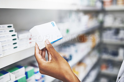 Buy stock photo Cropped shot of an unrecognizable pharmacist picking medication from the shelves