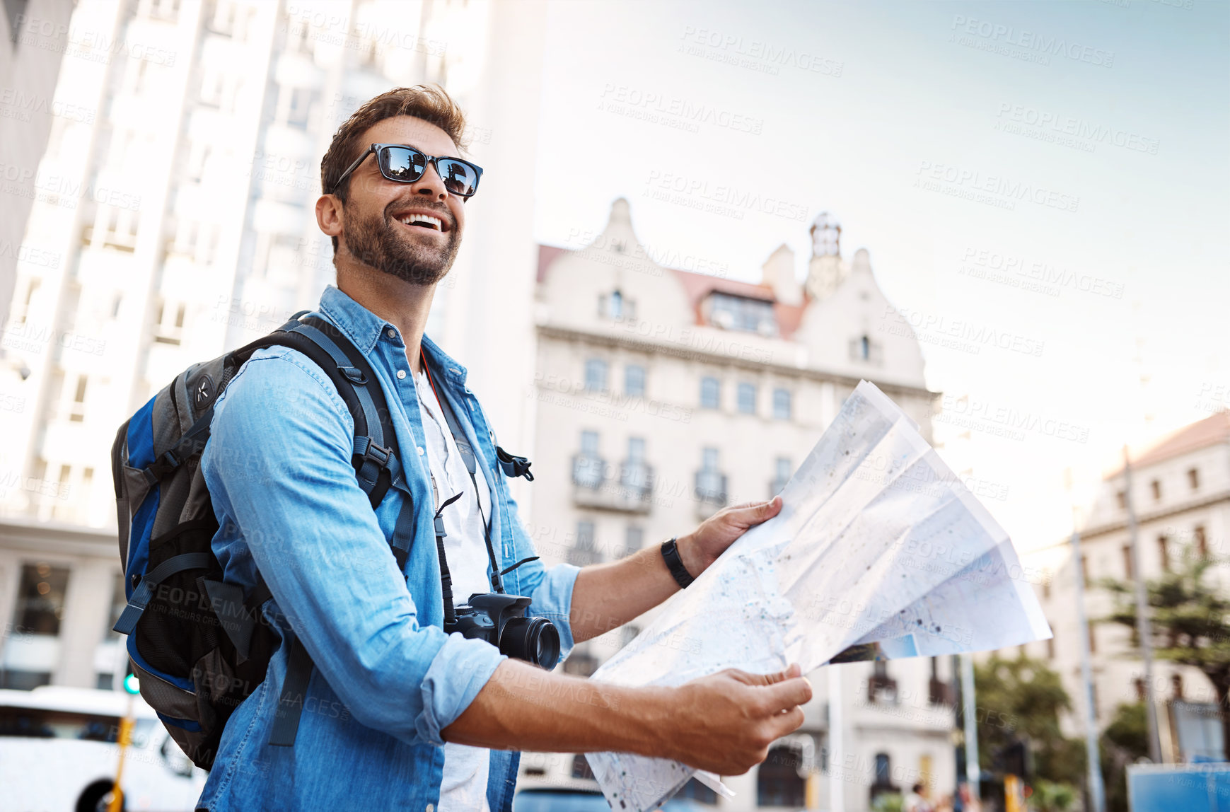 Buy stock photo Cropped shot of a handsome young man looking at a map while touring a foreign city