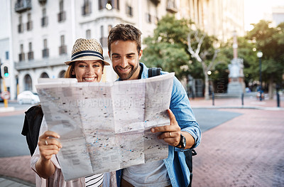 Buy stock photo Cropped shot of an affectionate young couple using a map while exploring a foreign city