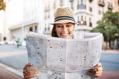 Buy stock photo Cropped shot of an attractive young woman looking at a map while touring a foreign city
