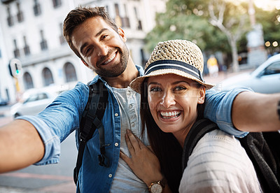 Buy stock photo Cropped portrait of an affectionate young couple taking a selfie while out in a foreign country