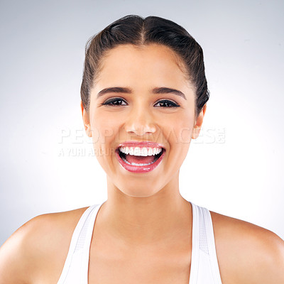 Buy stock photo Studio portrait of a beautiful and cheerful young woman posing against a grey background