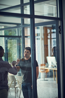 Buy stock photo Shot of two young businessmen having an argument in a modern office