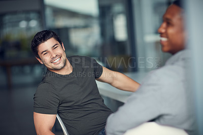 Buy stock photo Shot of two young businessmen having a meeting in a modern office