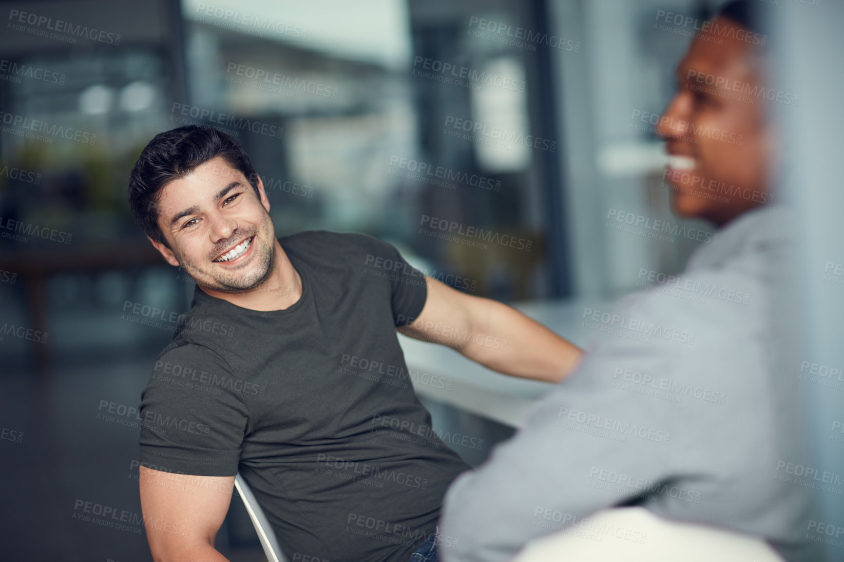 Buy stock photo Shot of two young businessmen having a meeting in a modern office