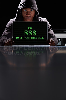 Buy stock photo Shot of a hacker using a laptop with the words “Pay $$$ to get your files back” on it