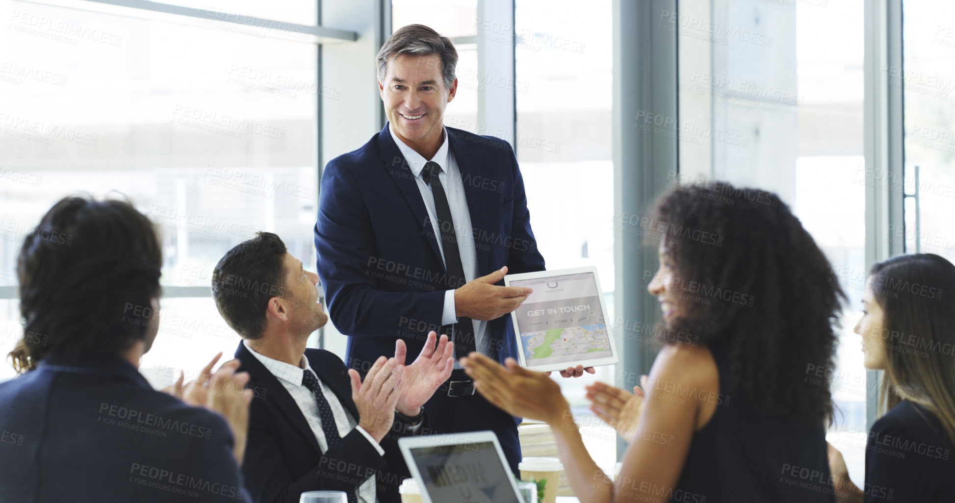 Buy stock photo Cropped shot of a businessman using a digital tablet while giving a presentation to his colleagues in an office