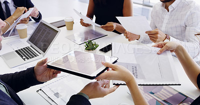 Buy stock photo Cropped shot of a group of businesspeople sitting around the boardroom table during a meeting