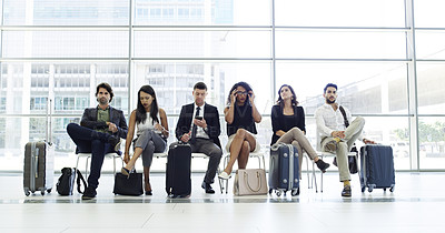 Buy stock photo Full length shot of a group of businesspeople sitting in an airport waiting room
