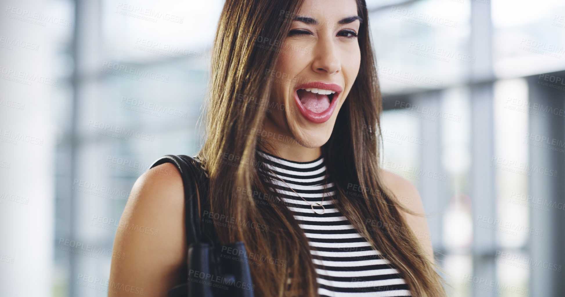 Buy stock photo Cropped shot of an attractive young businesswoman winking while walking through a modern office