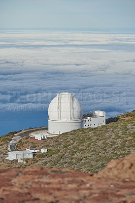 Buy stock photo Scenic view of an astronomy observatory dome in Roque de los Muchachos, La Palma, Spain. Landscape of science infrastructure or building against blue sky with clouds and copyspace abroad or overseas