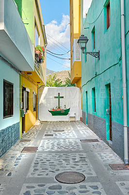 Buy stock photo Colorful old buildings with a wall with a cross or crucifix in the city of Santa Cruz de La Palma. Bright and vibrant homes or houses built by traditional architecture in the morning in a village