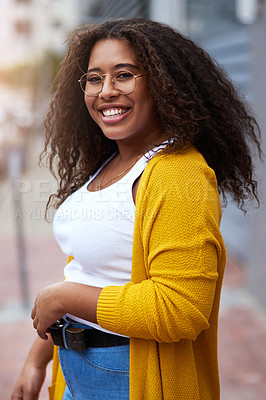 Buy stock photo Cropped portrait of a happy young woman standing outdoors in an urban setting