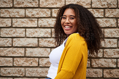 Buy stock photo Cropped portrait of a happy young woman posing against a brick wall