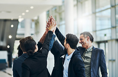 Buy stock photo Shot of a group of businesspeople forming a huddle with their hands at work