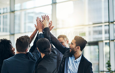 Buy stock photo Shot of a group of businesspeople forming a huddle with their hands at work