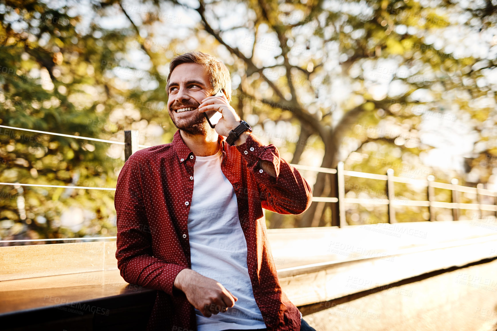 Buy stock photo Cropped shot of a handsome young man talking on his cellphone outside