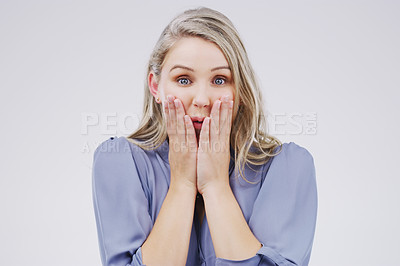 Buy stock photo Studio portrait of an attractive young woman looking shocked against a grey background