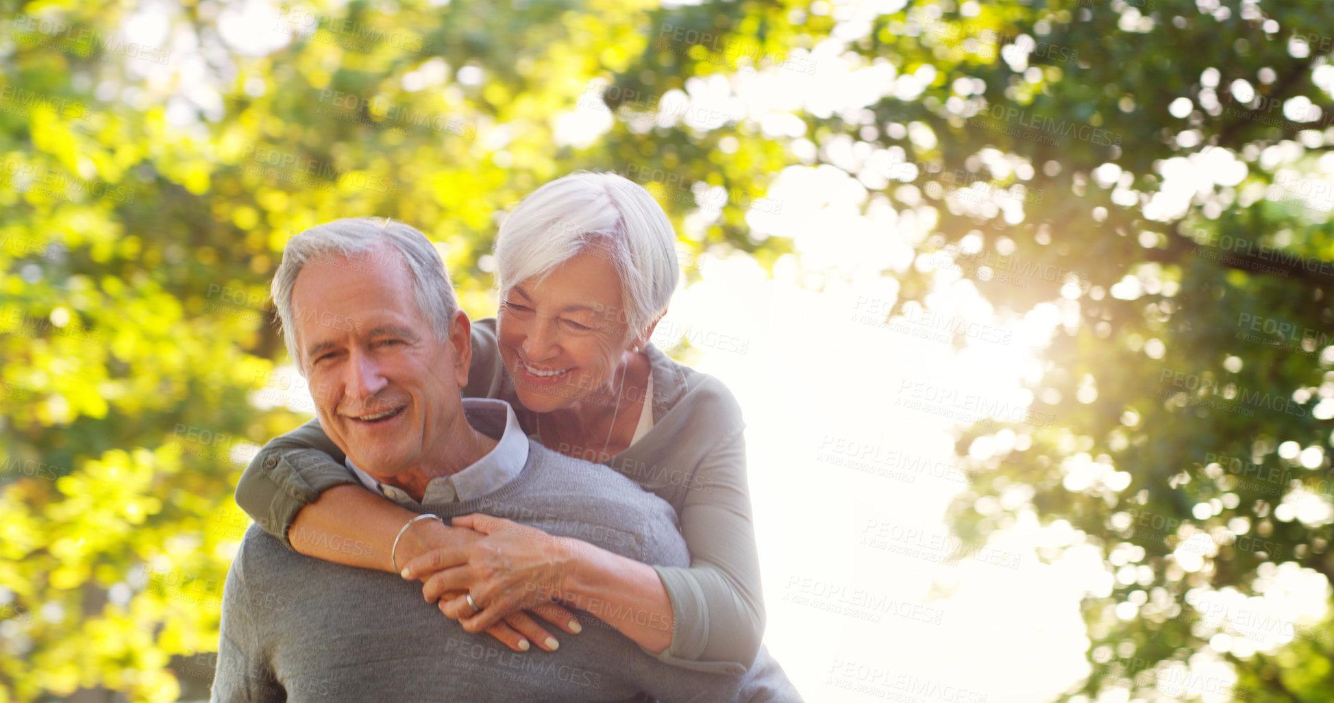 Buy stock photo Senior couple, piggy back and happy outdoor at a park with love, care and support. A elderly man and woman in nature for a fun walk, quality time and healthy marriage or retirement while playful