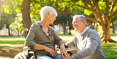 Buy stock photo Senior couple, wheelchair and happy outdoor at a park while talking with love, care and respect. A elderly man and woman with disability in nature for quality time, healthy marriage or retirement