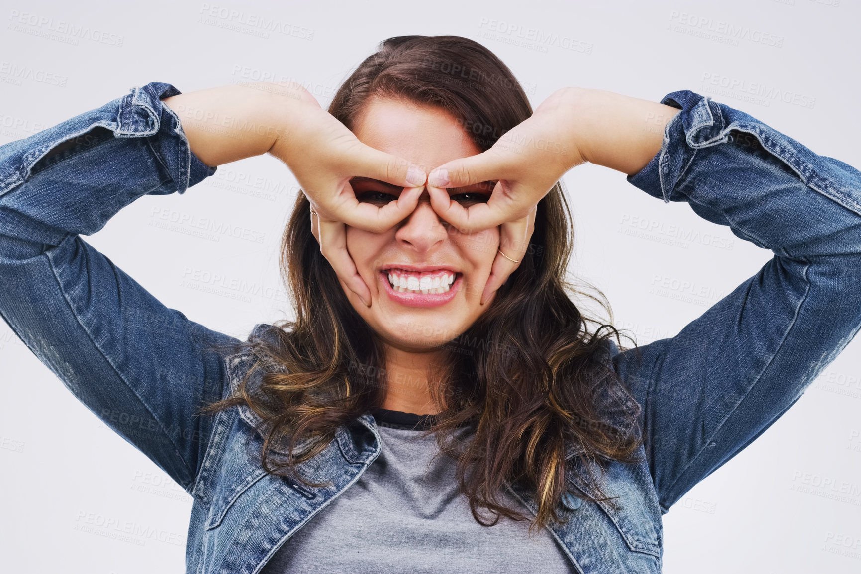 Buy stock photo Portrait, funny face and finger glasses with a woman in studio on a white background looking silly or goofy. Comedy, comic and smile with a crazy young female person joking indoor for fun or humor
