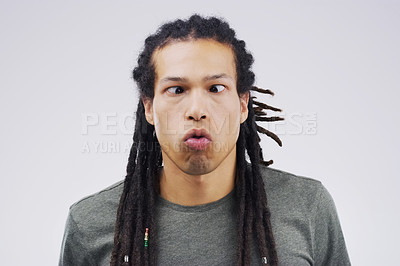 Buy stock photo Studio shot of a young man making a funny face against a gray background