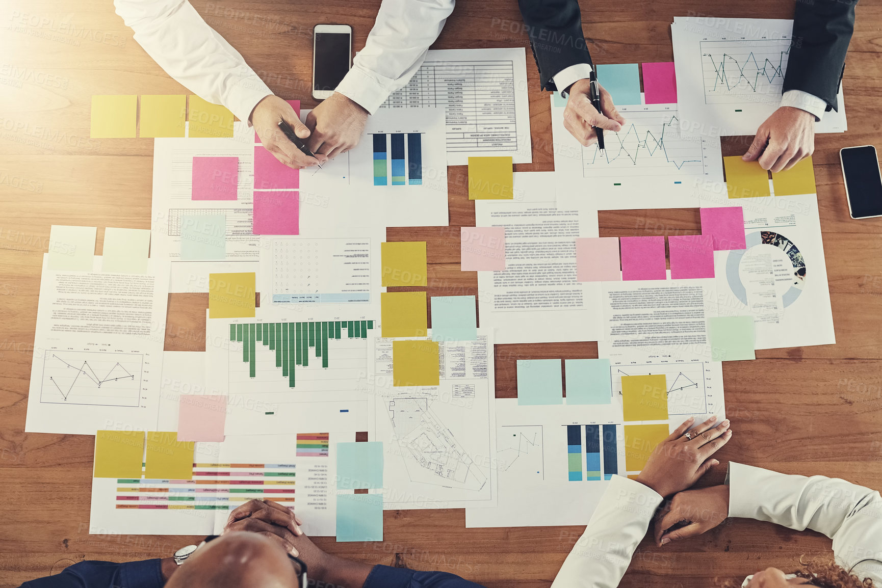 Buy stock photo High angle shot of a group of unrecognizable businesspeople having a meeting in their office