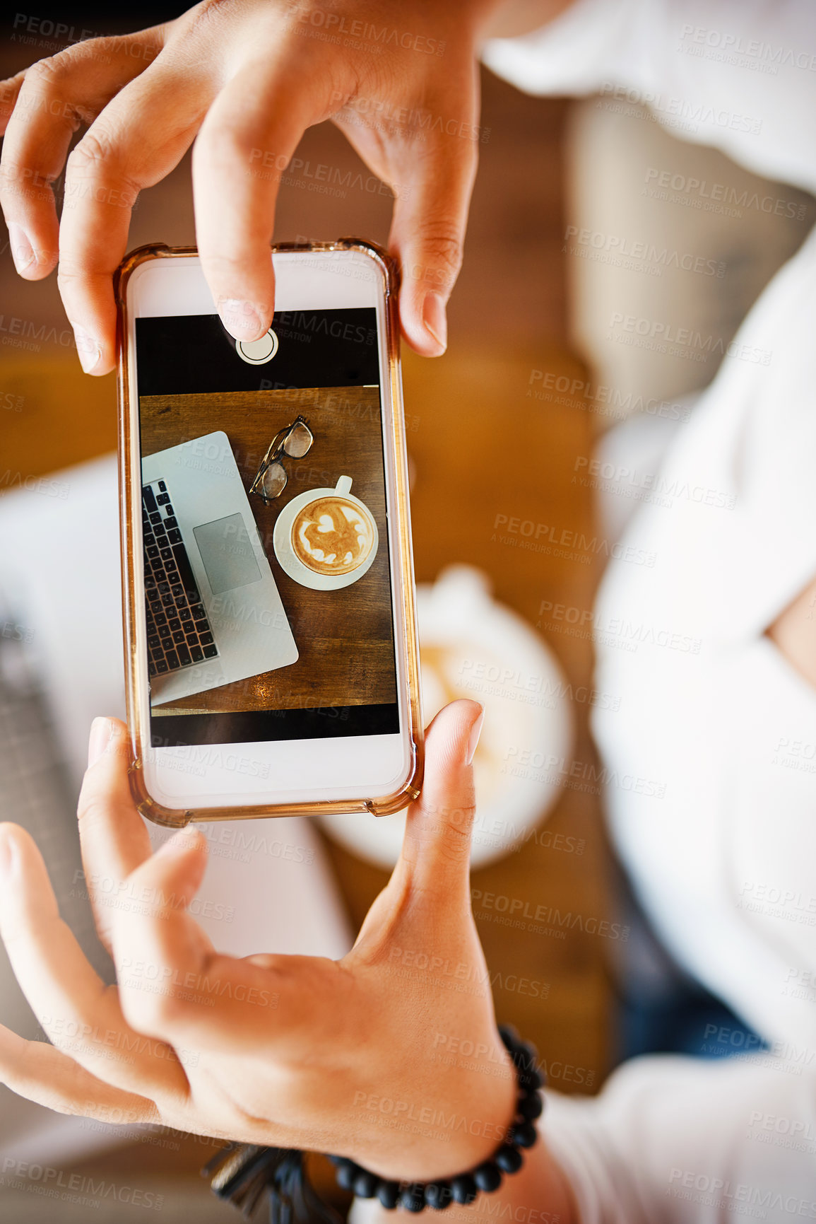 Buy stock photo Shot of a unrecognizable woman taking a picture with her cellphone of a cup coffee she just bought inside of a cafe