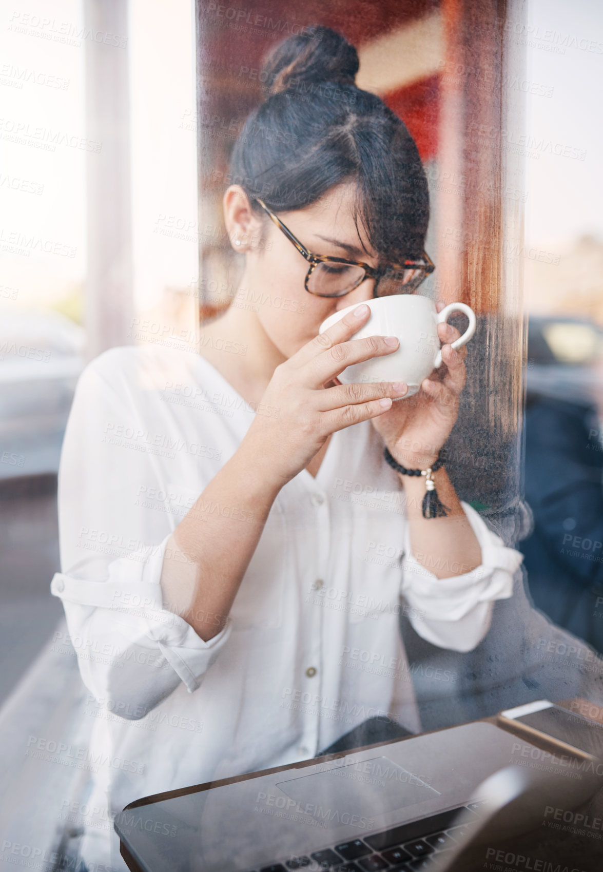 Buy stock photo Cropped shot of a beautiful young woman having a sip of her coffee she just bought inside of a cafe during the day