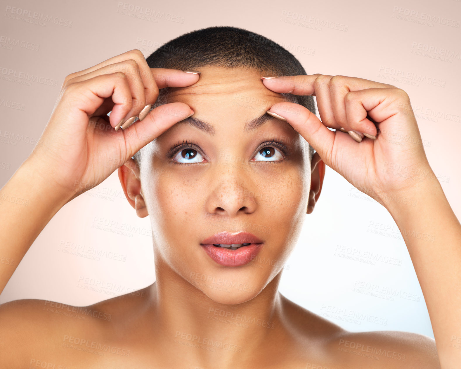 Buy stock photo Studio shot of a beautiful young woman squeezing her forehead against a grey background