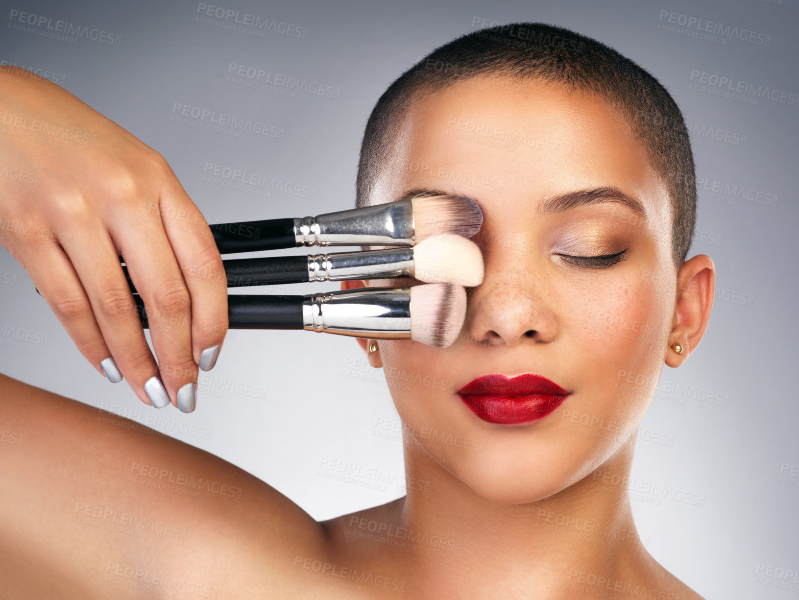Buy stock photo Studio shot of a beautiful young woman posing with a set of makeup brushes
