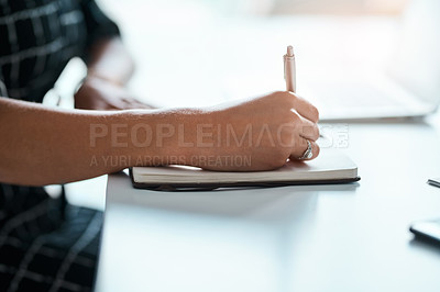 Buy stock photo Cropped shot of an unrecognizable young businesswoman writing on a notebook in an office