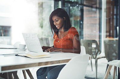 Buy stock photo Shot of an attractive young businesswoman working on a laptop at her office desk