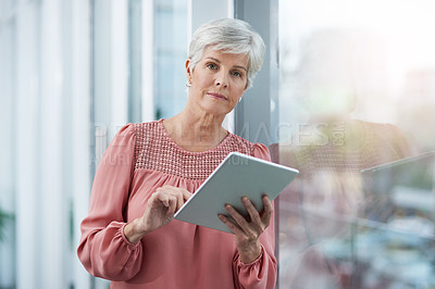 Buy stock photo Portrait of a mature businesswoman using her digital tablet at work