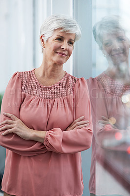 Buy stock photo Shot of a cheerful mature businesswoman posing with her arms folded in her office at work