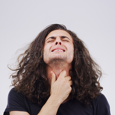 Buy stock photo Studio shot of a young man suffering with a sore throat against a grey background