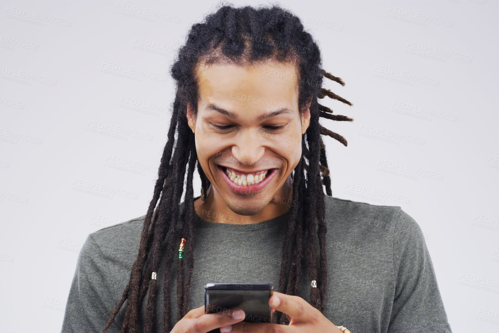Buy stock photo Studio shot of a happy young man using his cellphone
