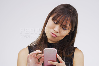 Buy stock photo Woman, smartphone and typing in studio background for social media post, reading text or online blog. Female person, mobile or tech by white backdrop for internet news and website notification