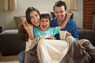 Buy stock photo Shot of a cheerful young couple and their son spending some time together at home