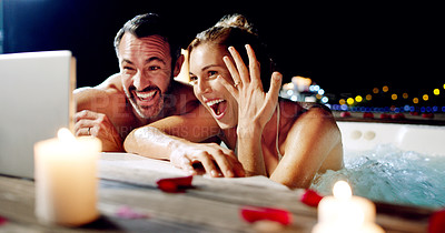 Buy stock photo Shot of an affectionate mature couple announcing their engagement over video chat while relaxing in a hot tub