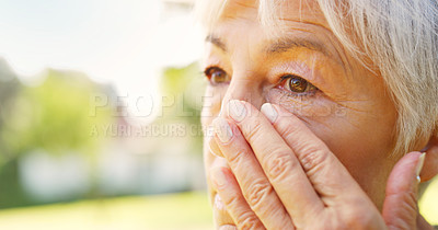 Buy stock photo Closeup shot of a sad senior woman wiping tears off her face outdoors
