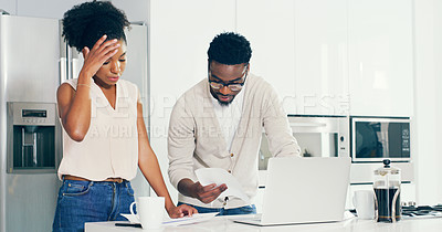Buy stock photo Shot of a young couple completing some paperwork together in the kitchen at home