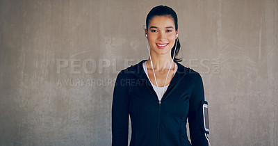 Buy stock photo Cropped studio portrait of an attractive young woman listening to music while working out