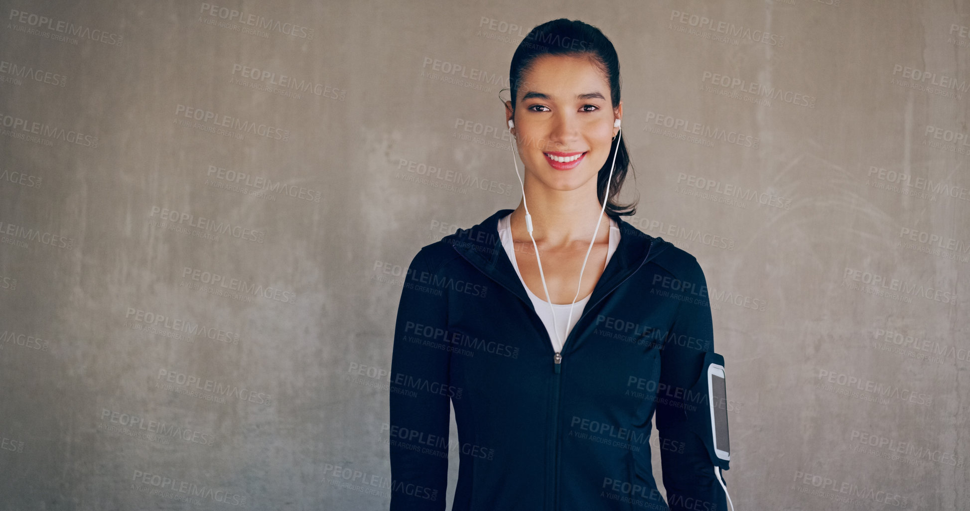 Buy stock photo Cropped studio portrait of an attractive young woman listening to music while working out