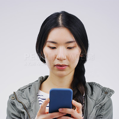 Buy stock photo Phone, online and face of Asian woman in studio for social media, internet and typing message. Communication, white background and Korean female person on smartphone for website, mobile app and text
